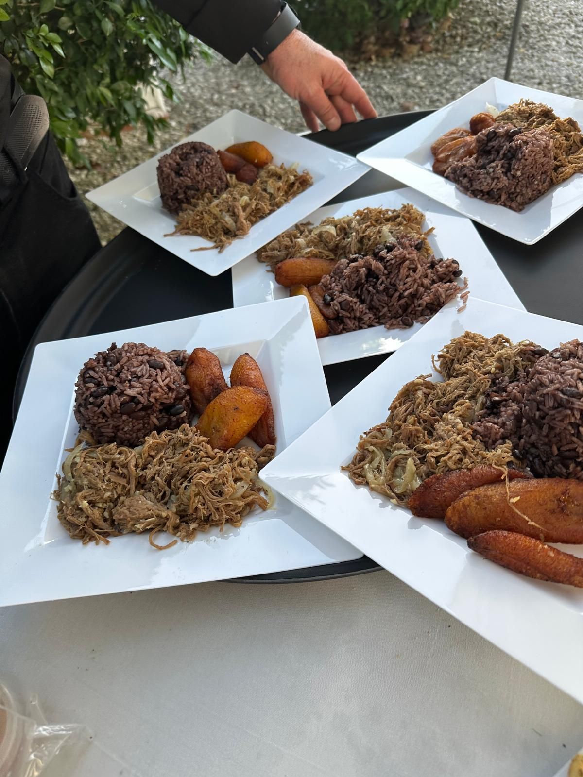 Plates of ropa vieja, black beans and rice and sweet plantains