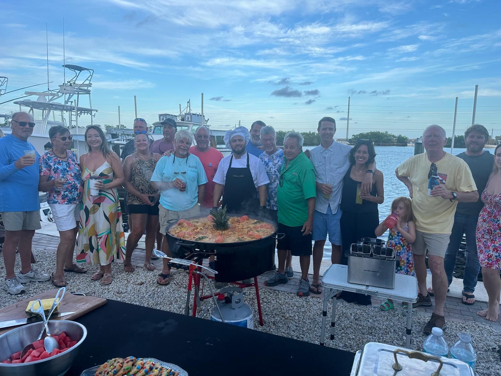 Guests gathered around a paella at a dockside party