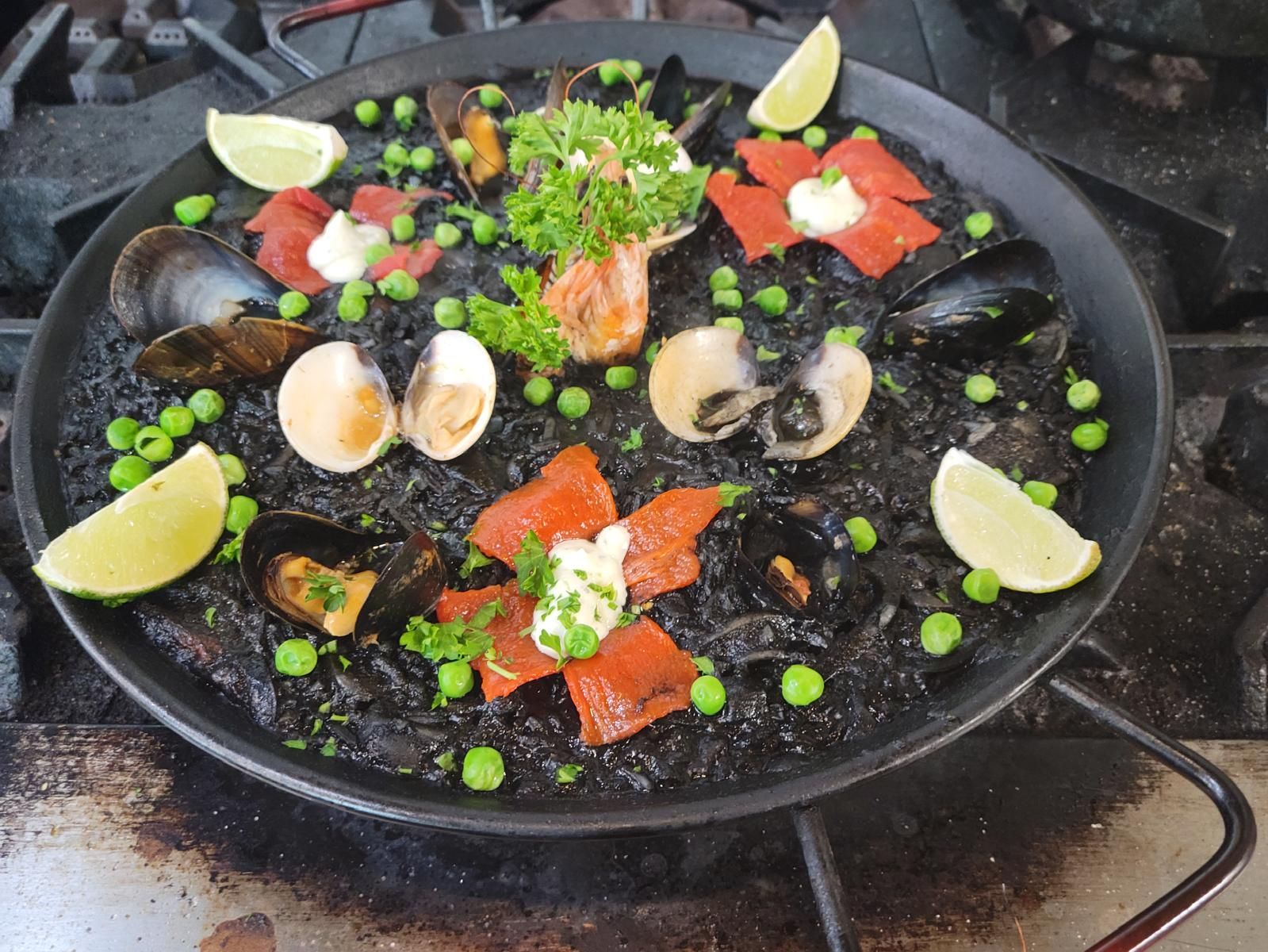 Black paella with squid ink, salmon and clams