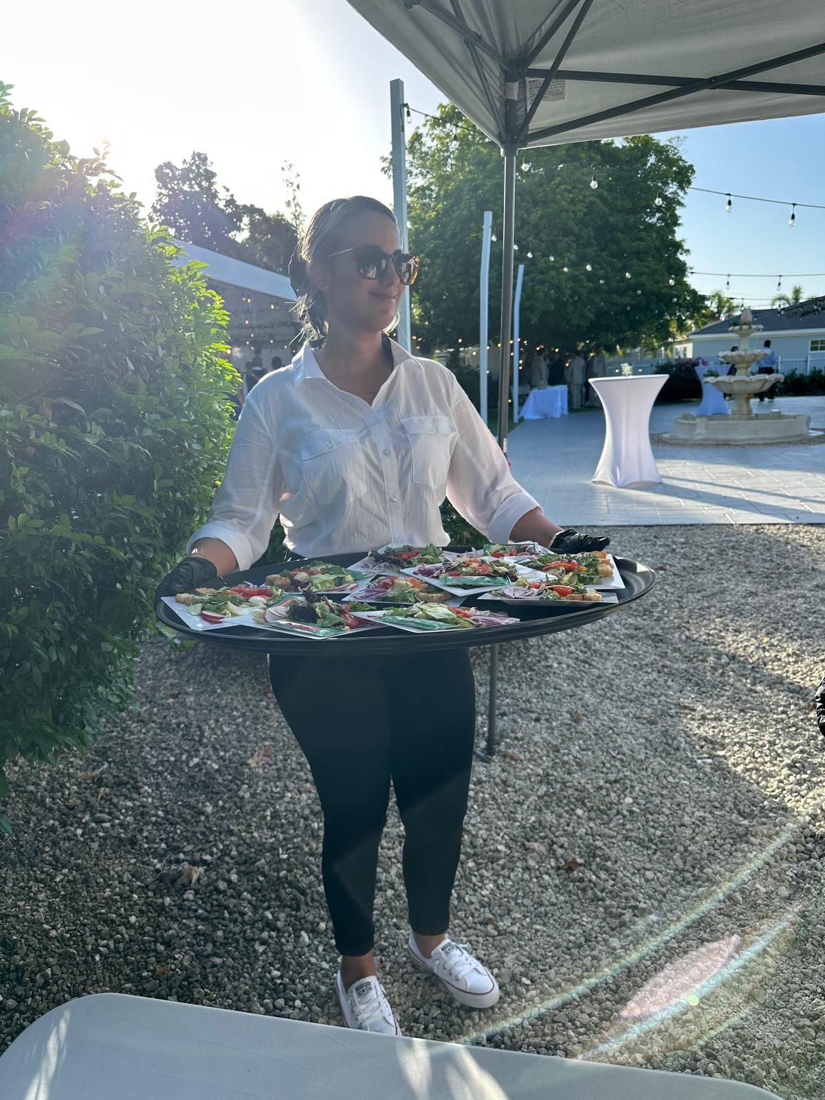 Server carrying a tray of plated appetizers