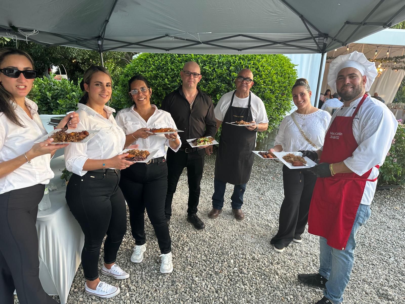 Catering team holding plates of paella